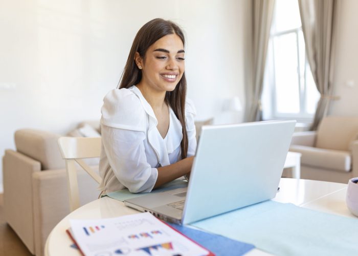 Focused businesswoman presenting charts and graphs on video call online. Young business woman having conference call with client on laptop. Closeup business woman working laptop computer indoor.